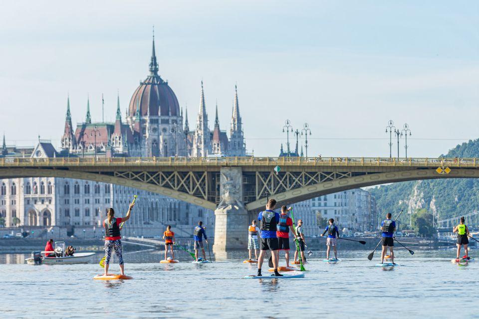 Touristes faisant du paddle sur le danube à budapest devant le parlement
