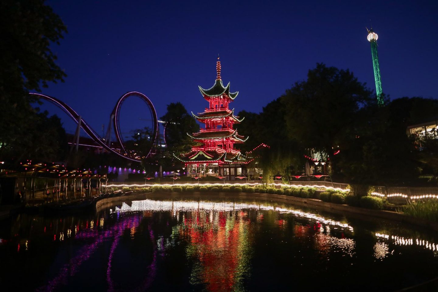 Jardins de Tivoli à Copenhague avec la pagode chinoise et les montagnes russes emblématiques en arrière-plan de nuit