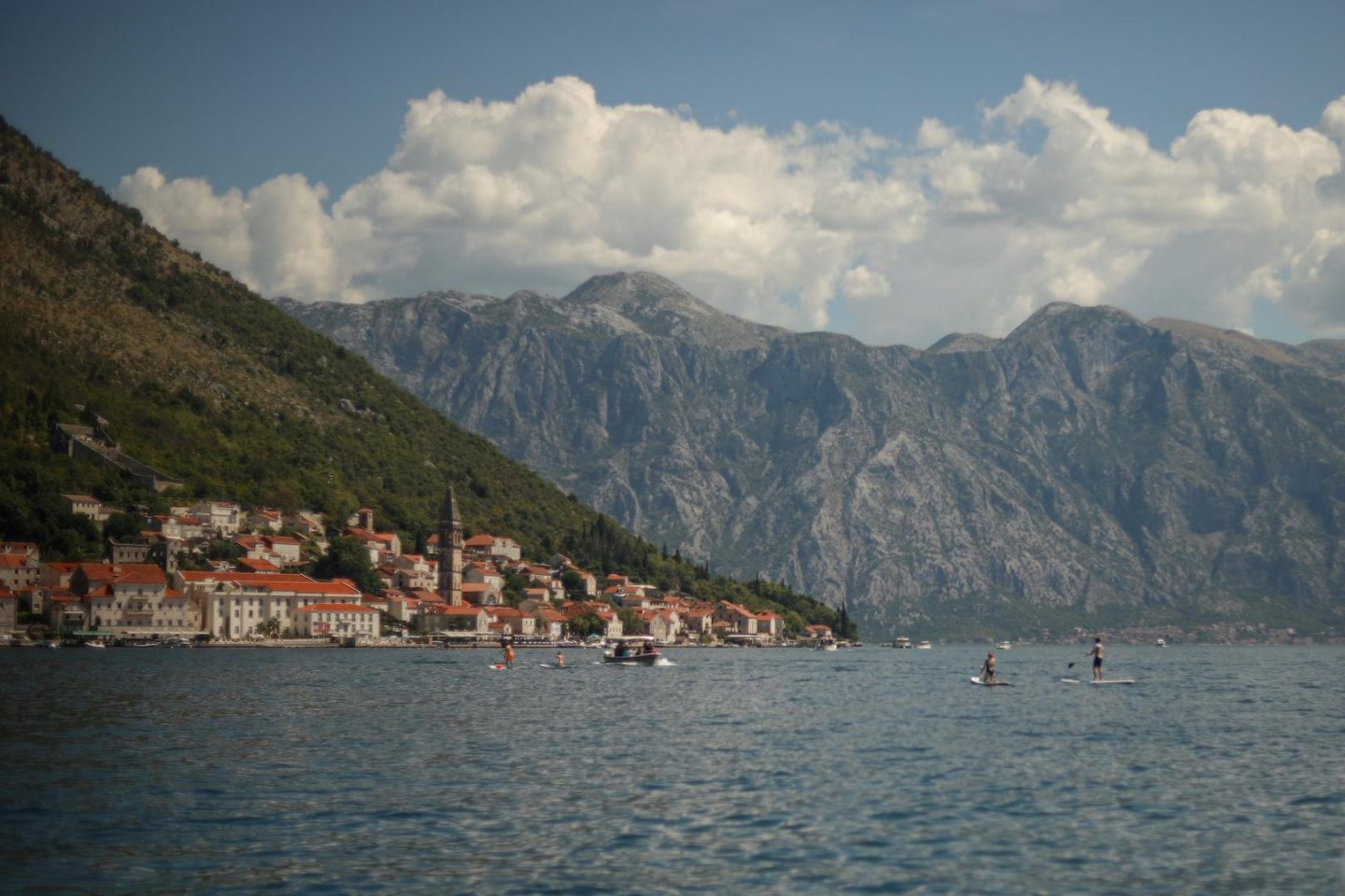 Vu de Perast et des montagnes avec des vacanciers qui font du paddle dans les bouches de Kotor